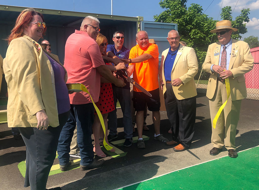 The Loop board members and members of the Chamber of Commerce join to cut the ribbon